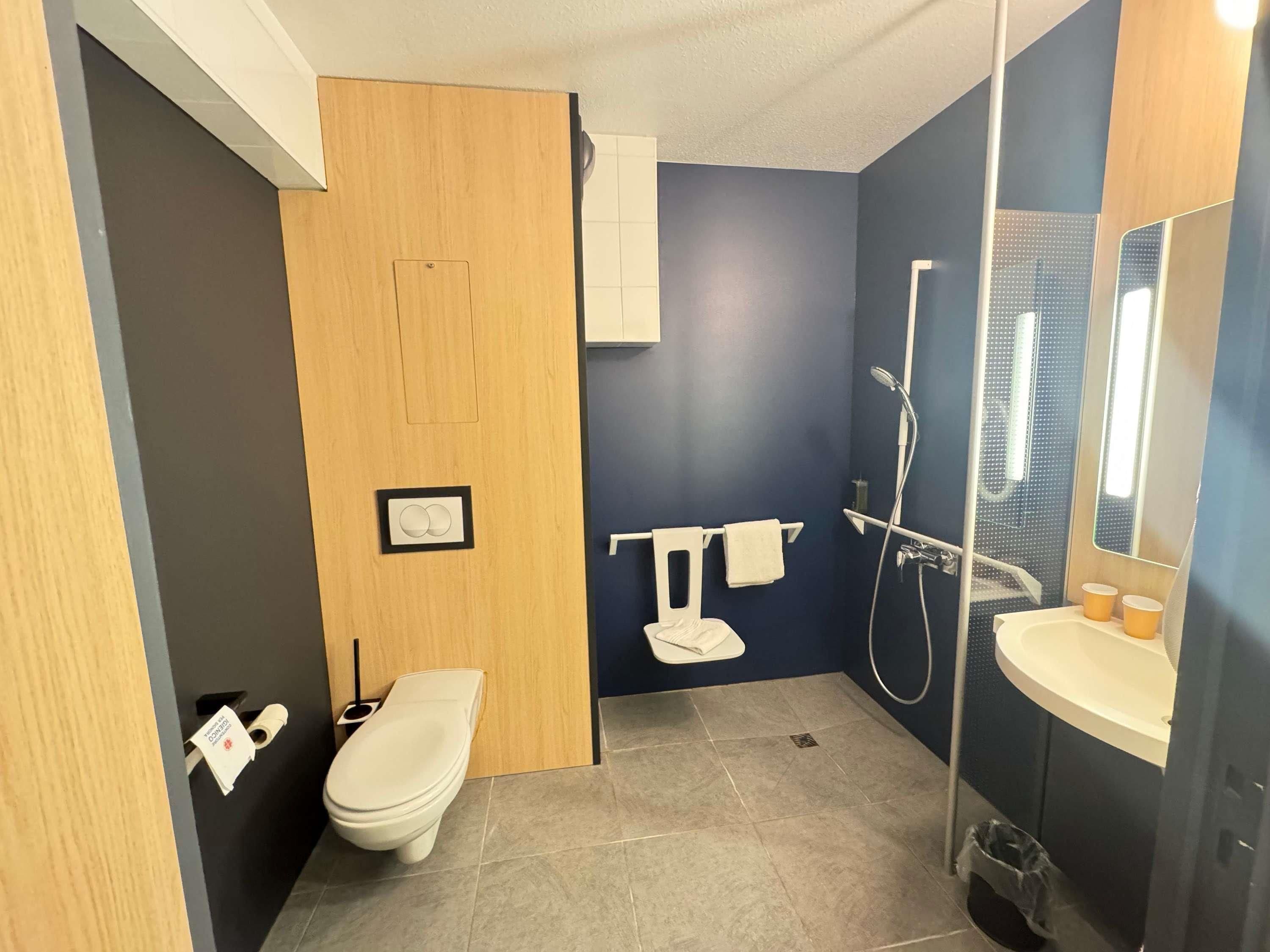 Ein modernes Badezimmer mit Toilette, Waschbecken und Dusche.