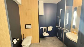 Ein modernes Badezimmer mit Toilette, Waschbecken und Dusche.