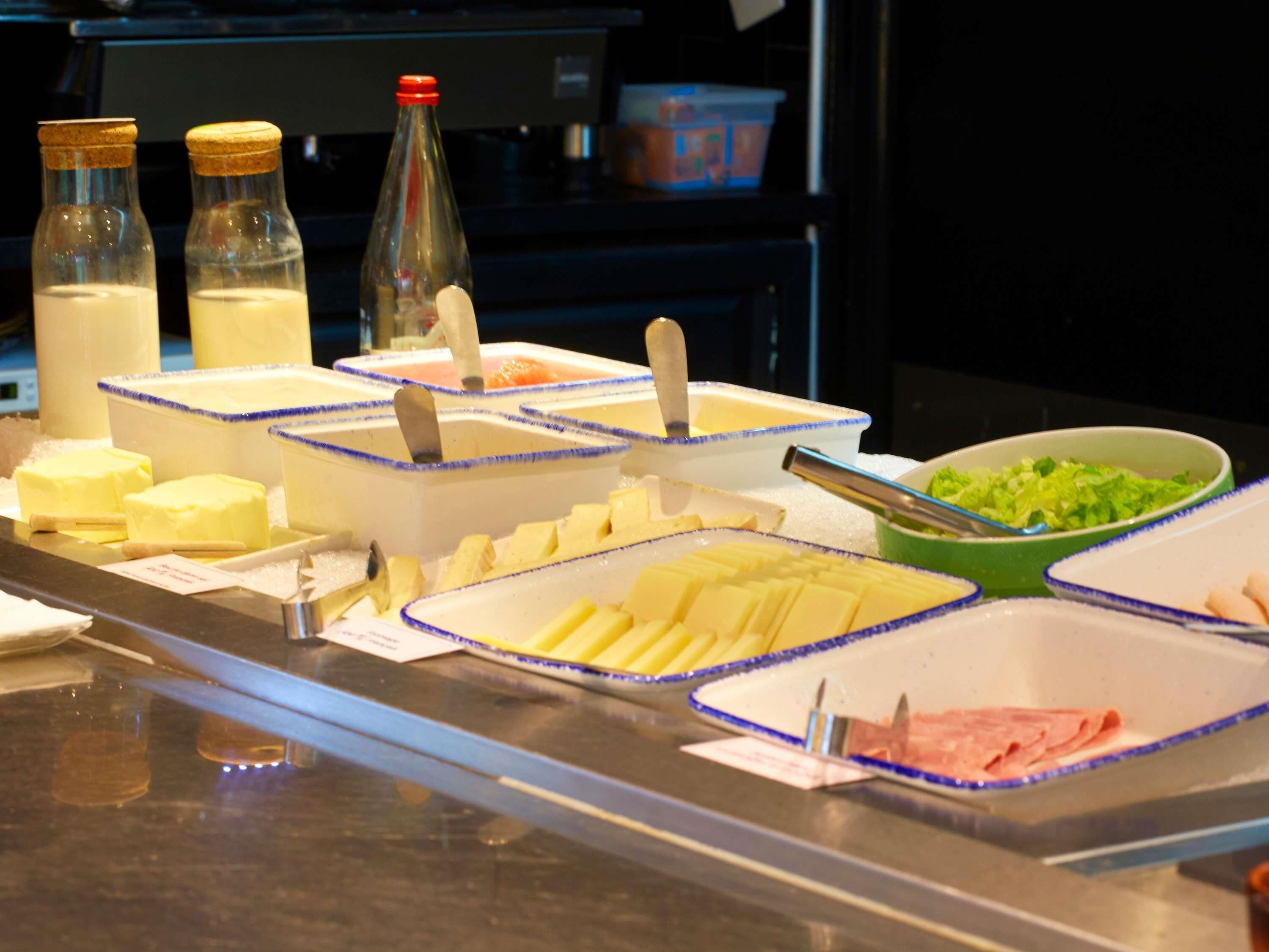 A buffet with various food items and condiments.