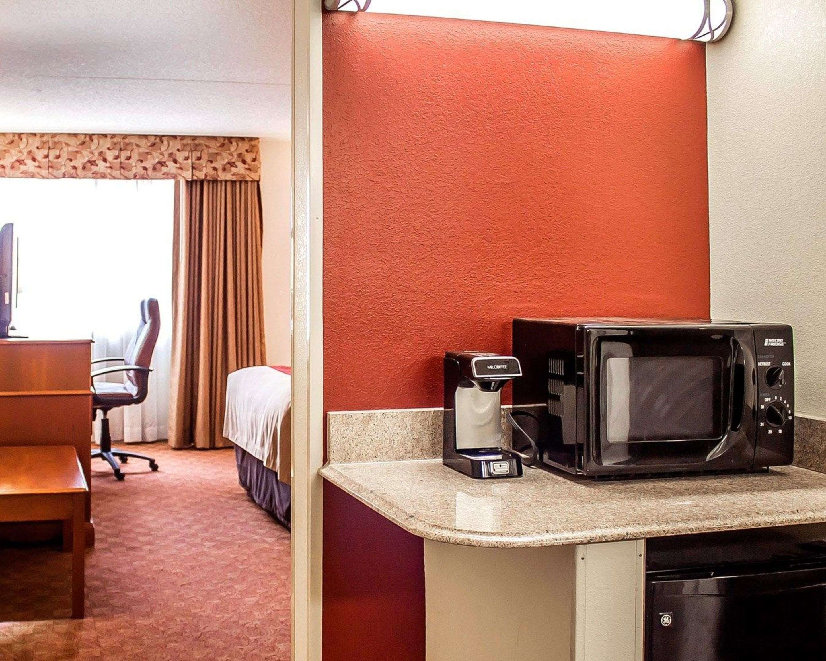 Une chambre d’hôtel dotée d’un coin cuisine comprenant un four à micro-ondes et une machine à café.