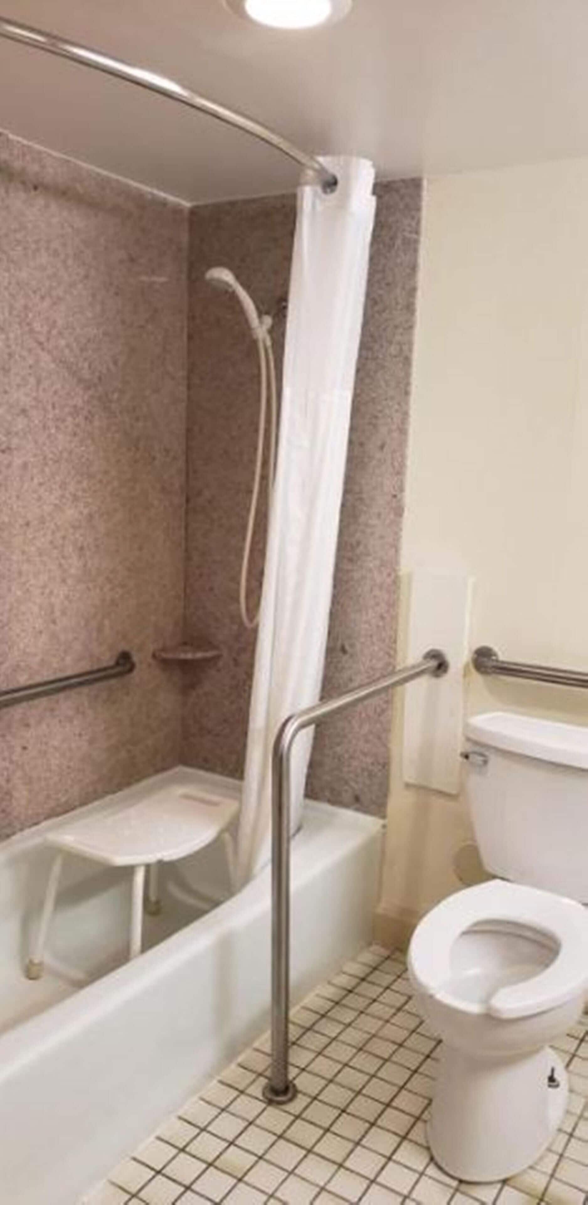 A bathroom with a bathtub, shower, and toilet.