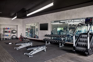 A gym with weightlifting equipment, treadmills, and exercise balls.