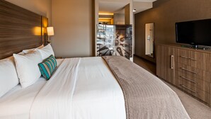 A hotel room with a large bed, a TV, and a wardrobe. - Executive Inn & Suites Embarcadero Cove (Oakland)