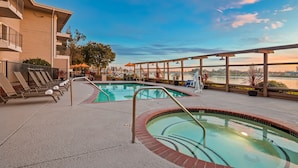 A pool area with lounge chairs and a view of a body of water. - Executive Inn & Suites Embarcadero Cove (Oakland)