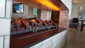 A modern reception area with a stone wall and a wooden ceiling. - Executive Inn & Suites Embarcadero Cove (Oakland)