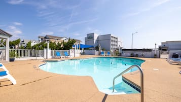 Una piscina al aire libre, sillones reclinables de piscina