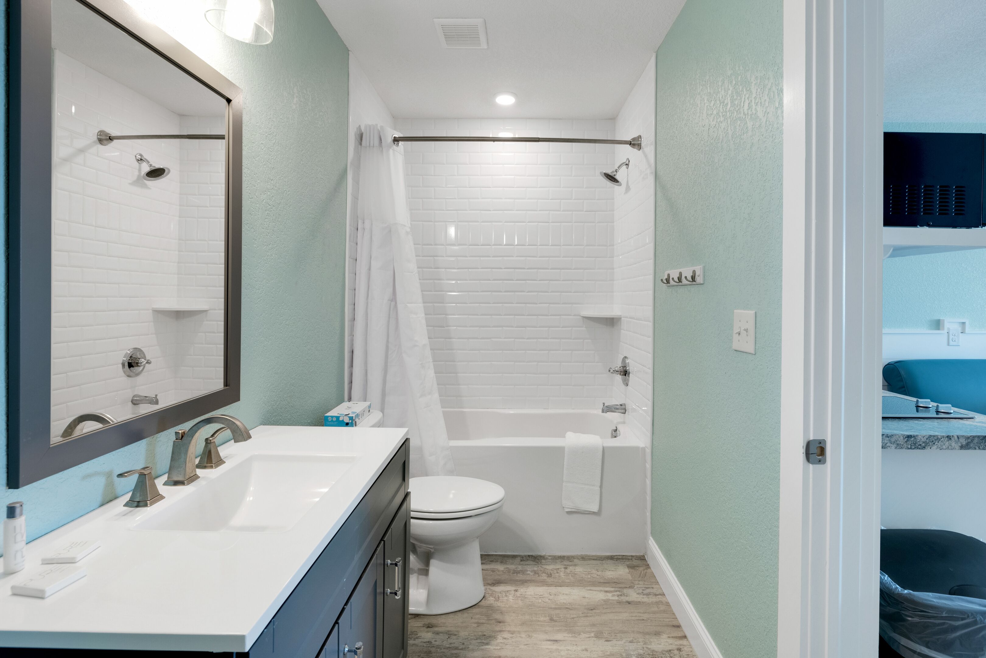 A bathroom with a white sink, two faucets, a toilet, and a bathtub.