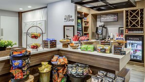A snack bar with various food items and a refrigerated section. - Hilton Garden Inn Boston/Waltham (Waltham)