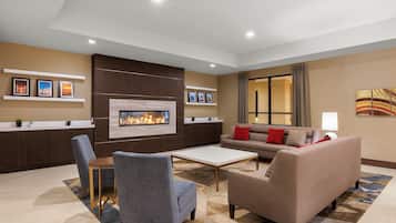 Ein modernes Wohnzimmer mit Kamin, Sofas, Couchtisch und Fernseher.