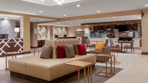 Eine moderne Lobby mit Sitzgelegenheiten, einer Rezeption und einer Bar.