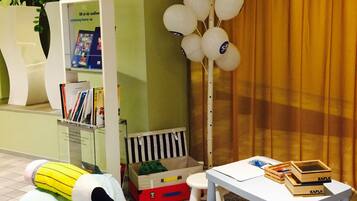 Children can play and learn in this cozy space with a play table, bean bag chair, and bookshelf.