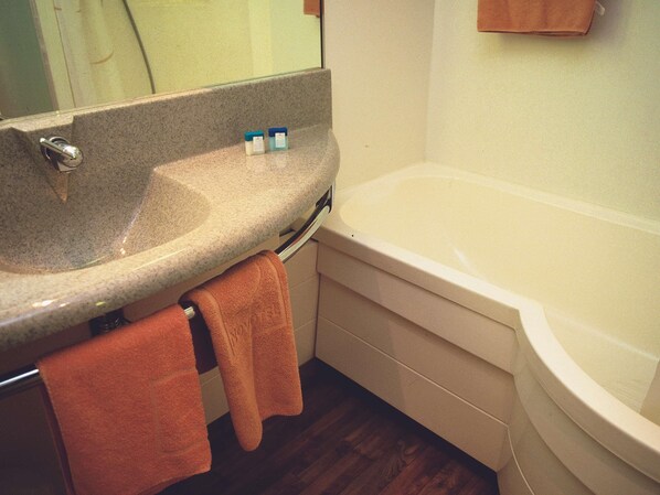 Un baño con lavabo, espejo y bañera.