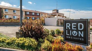 A sign for Red Lion Inn & Suites with a clear view of the building's exterior and surrounding landscaping.