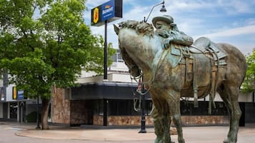 Una estatua de un jinete sobre un caballo, una farola y un letrero de restaurante.