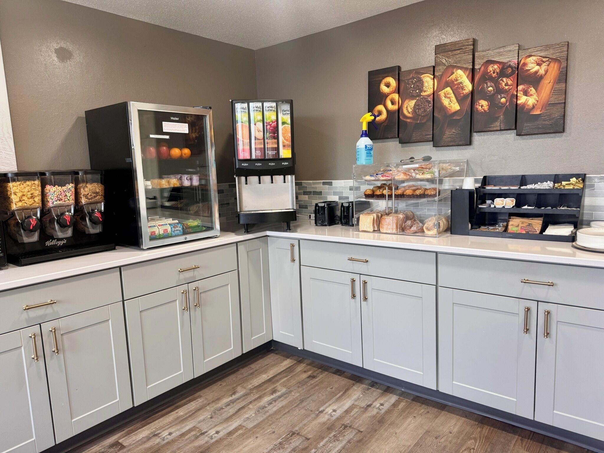 A kitchenette with a coffee machine, a juice dispenser, and a refrigerator with beverages.