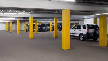A multi-level parking garage with yellow pillars and several parked vehicles.