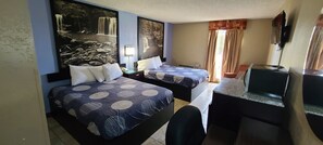 Quarto de hotel com duas camas, uma escrivaninha, uma cadeira, uma televisão e uma grande obra de arte na parede retratando cachoeiras.