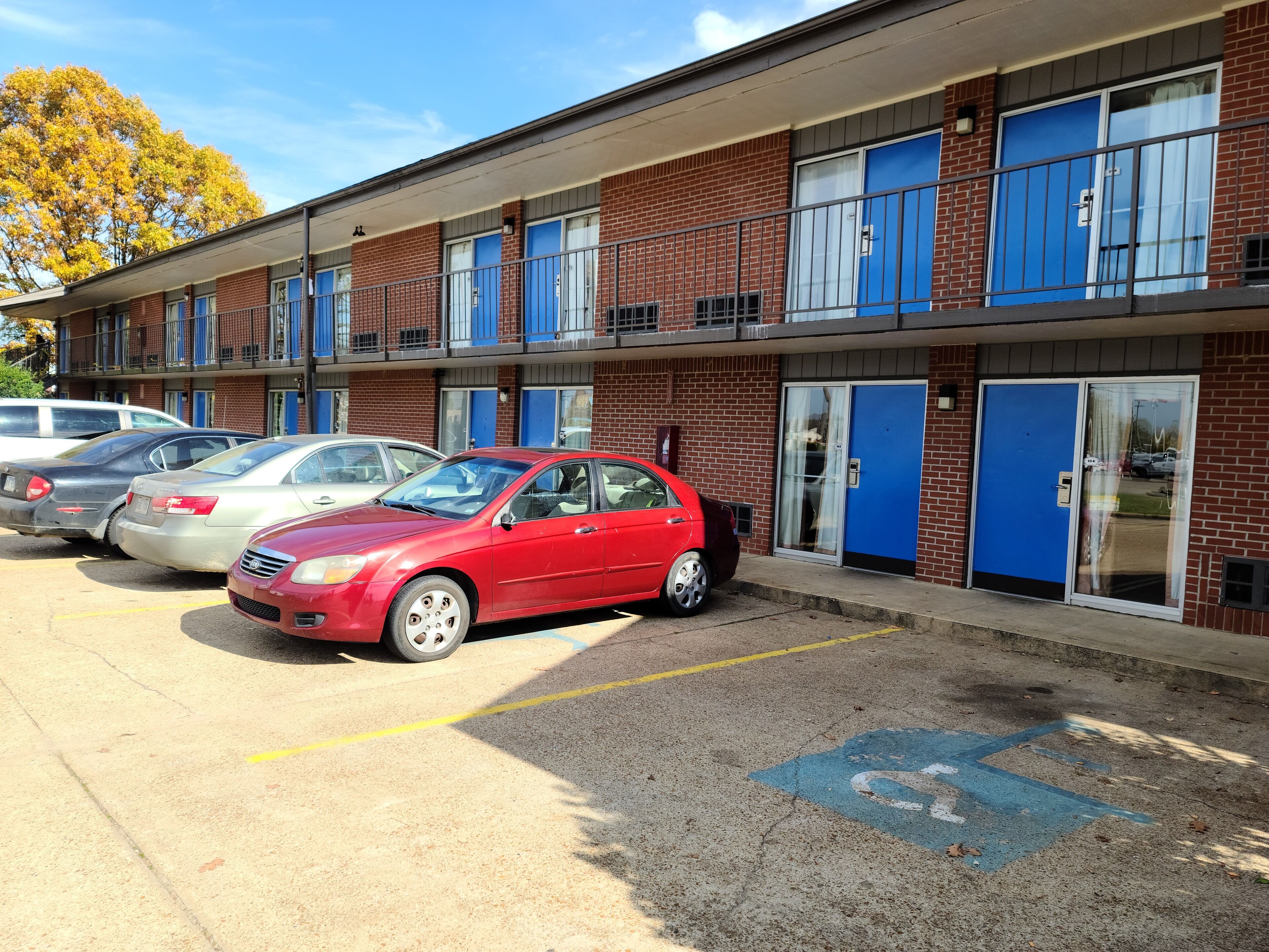A multi-story brick building with blue-framed windows and doors.