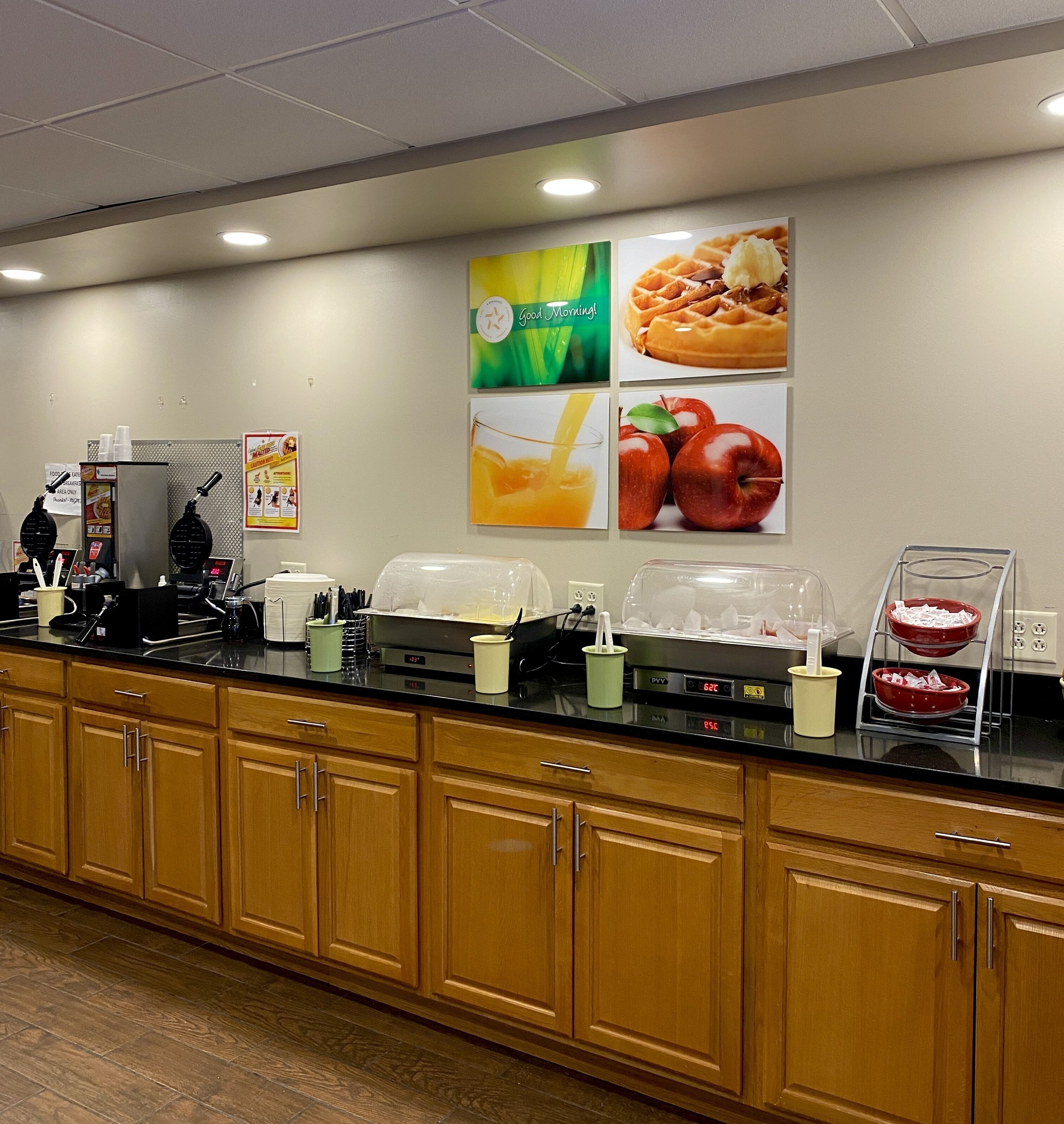 A breakfast bar with food displays, a coffee machine, and a fruit bowl.