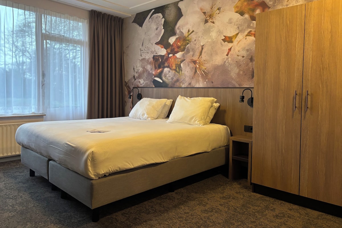 Ein Schlafzimmer mit einem großen Bett, einem Kleiderschrank und einer Wandmalerei.