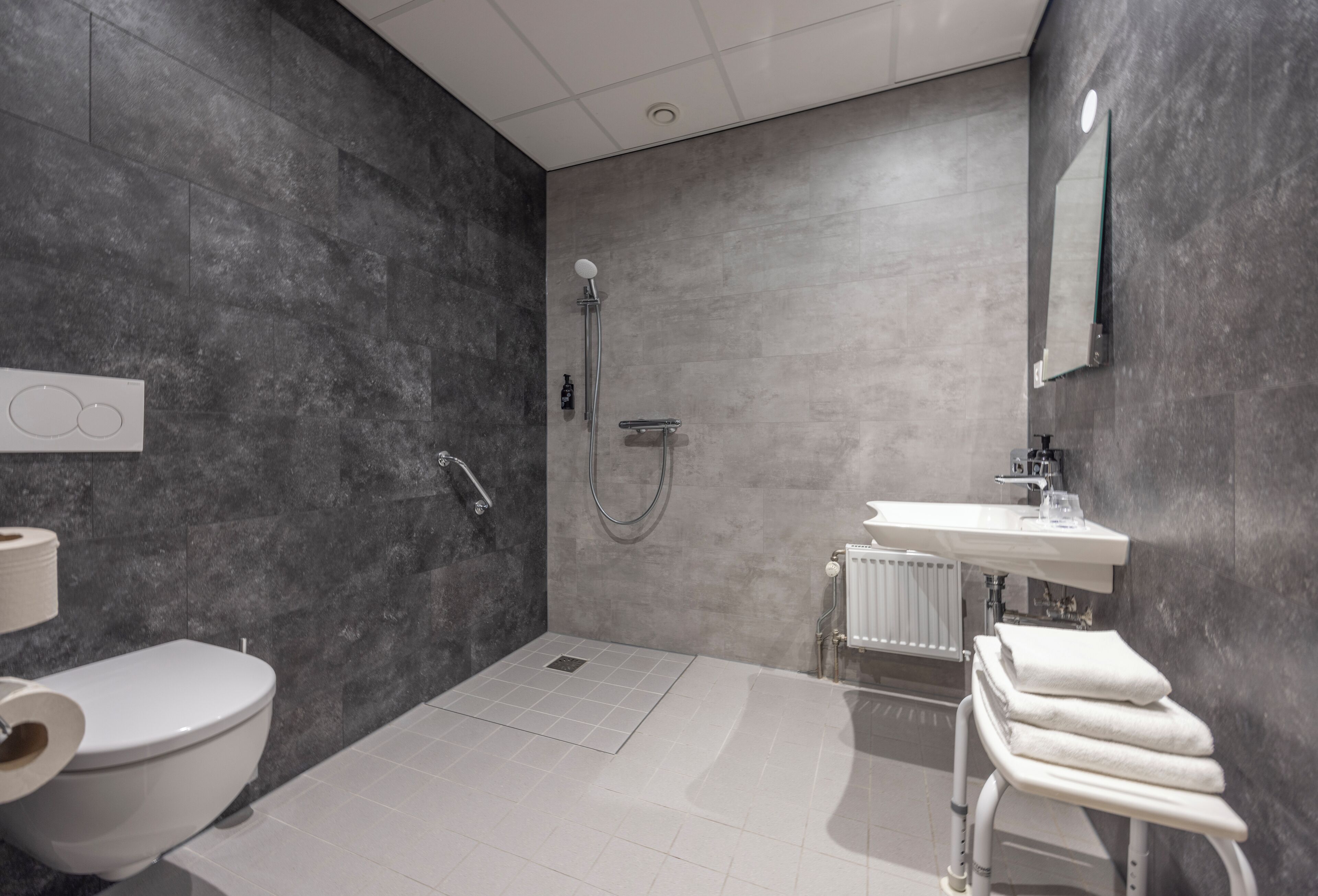 A modern bathroom with a shower, toilet, and sink.
