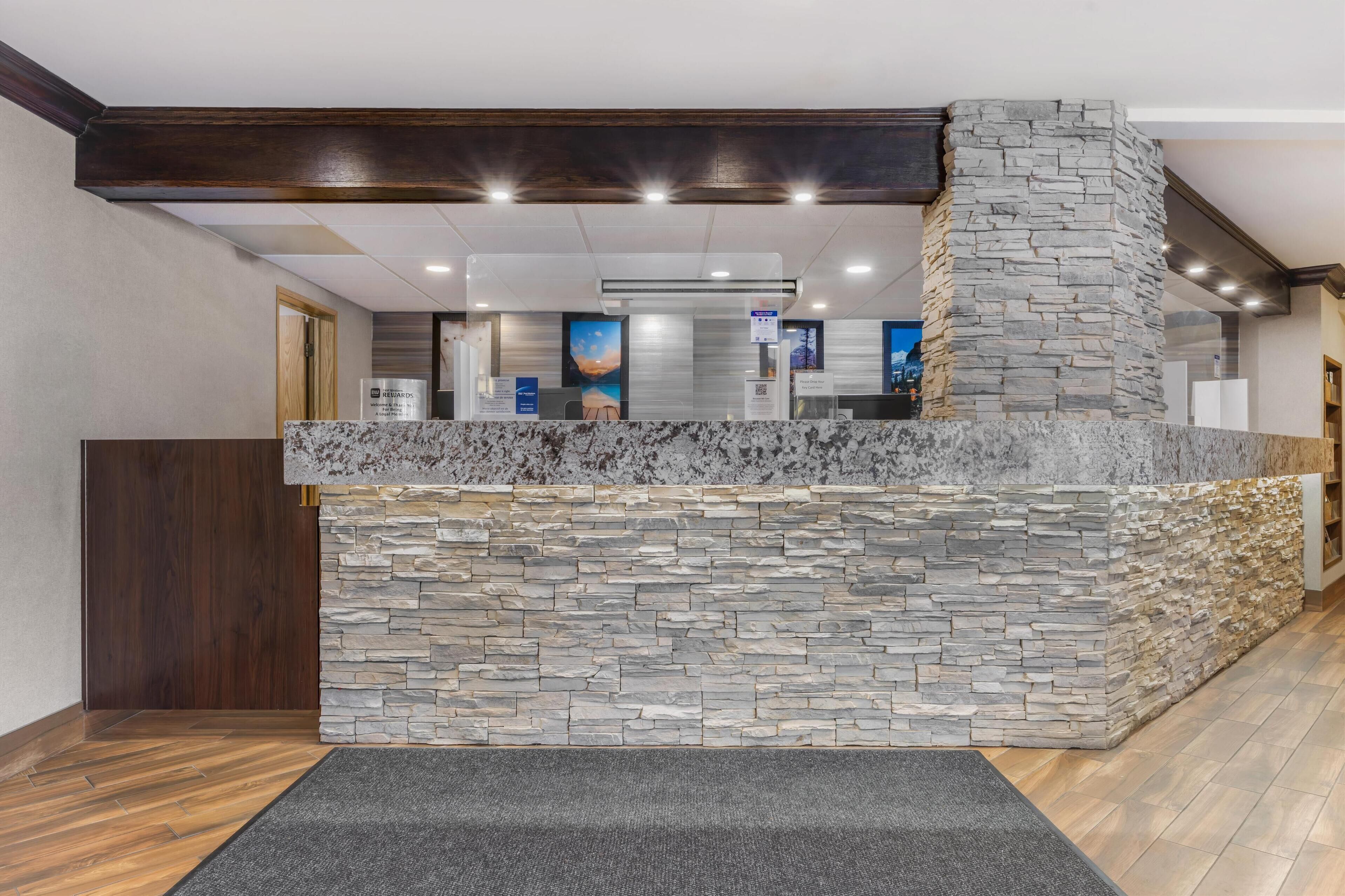 A reception area with a stone wall and a marble counter.