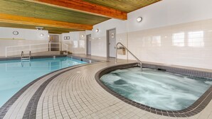 A swimming pool with a separate hot tub area, tiled walls, and wooden ceiling beams. - Best Western Plus Country Meadows Inn (Langley)
