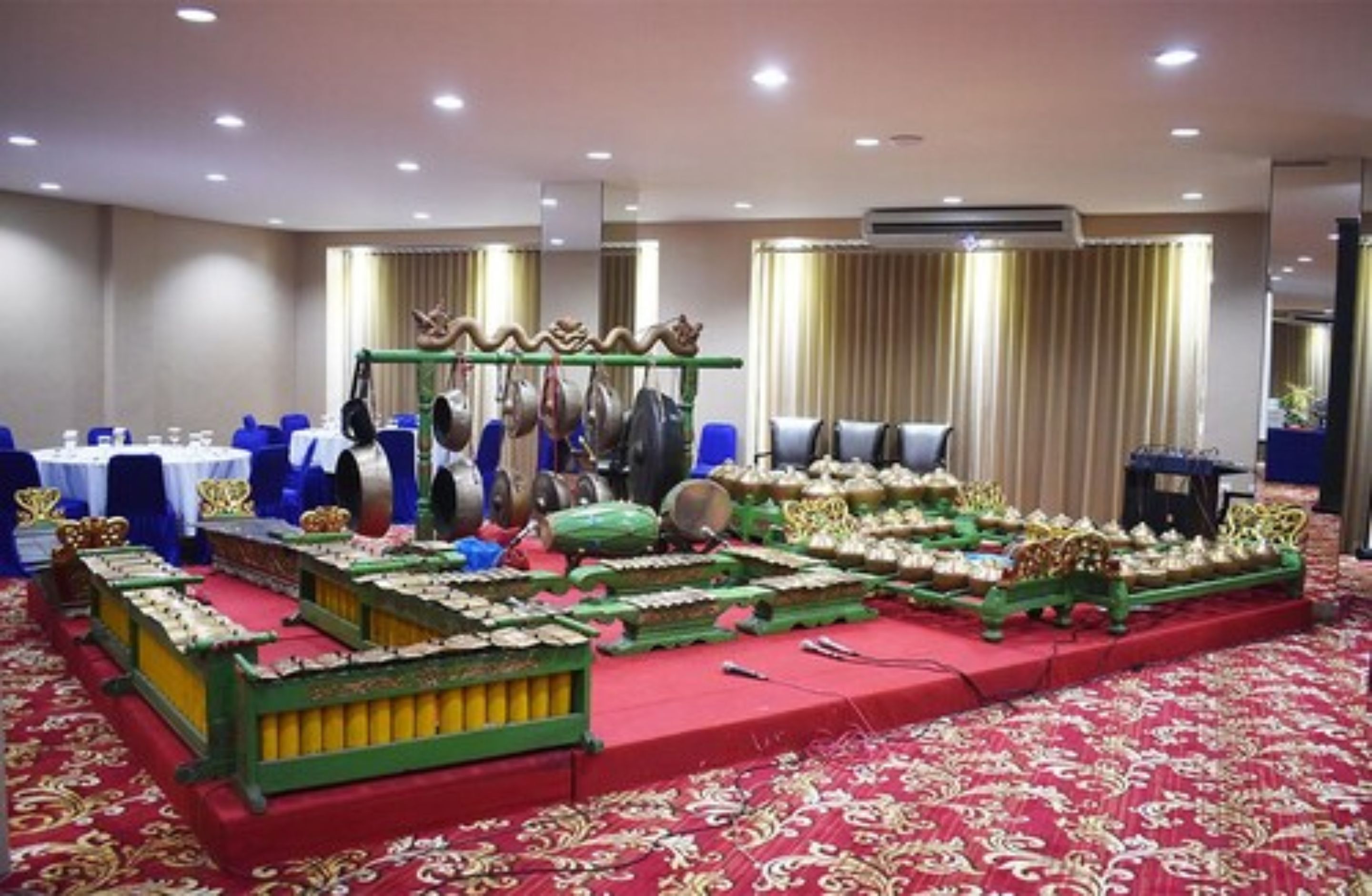 A banquet hall with tables set for a formal event, featuring traditional Chinese musical instruments and decorations.