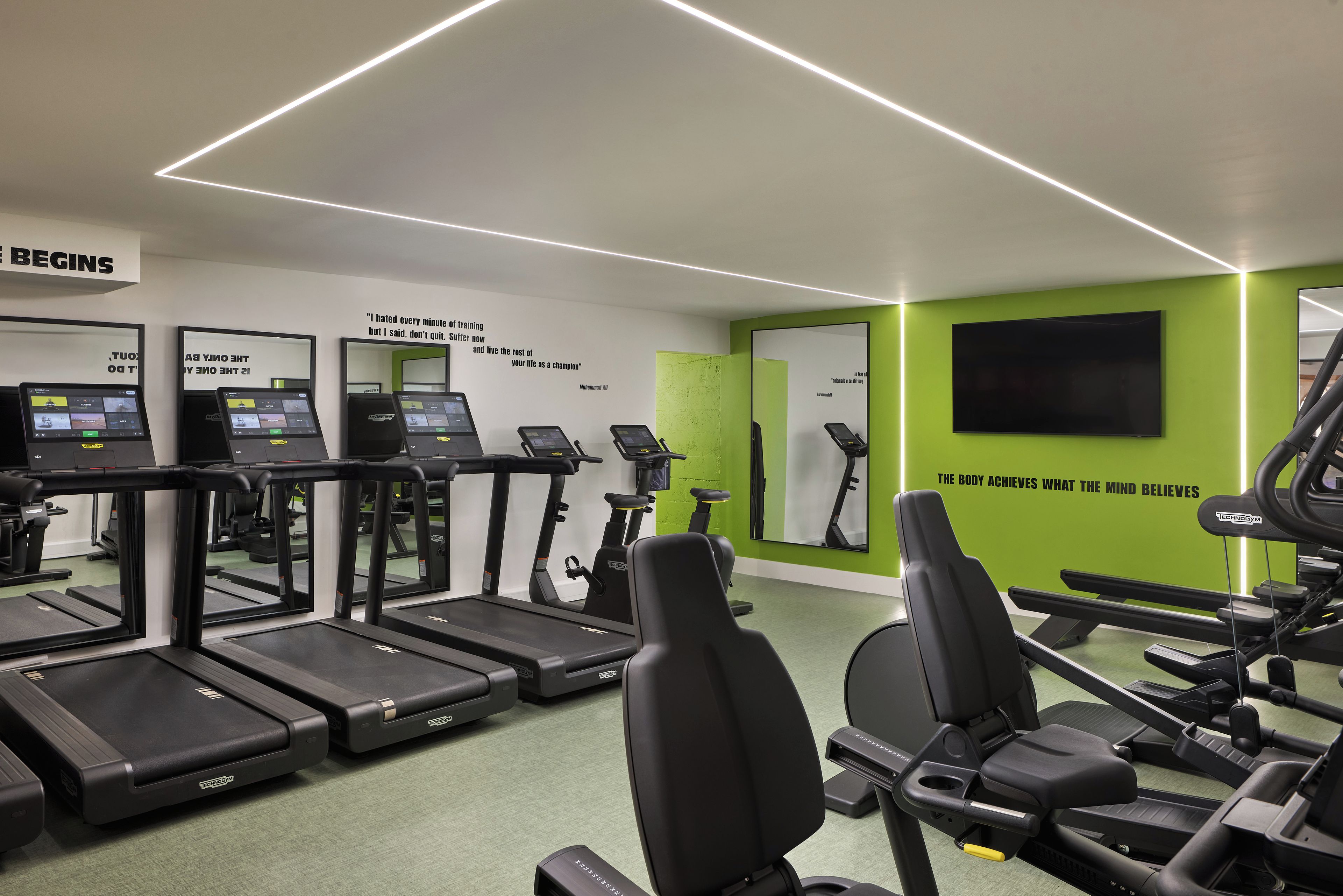 A gym with treadmills, stationary bikes, and exercise equipment.