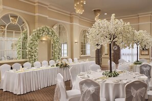 A banquet hall with round tables, white chairs, and floral decorations. - Parkway Hotel & Spa (Cwmbran)