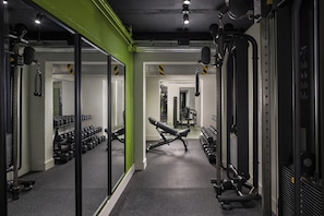 A gym with exercise equipment, mirrored walls, and a green accent wall. - Parkway Hotel & Spa (Cwmbran)