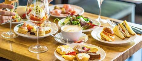Una mesa de comedor con diversos platos, copas de vino y una ensalada.