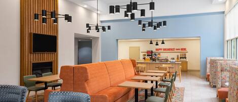 A modern interior with a sofa, chairs, tables, a fireplace, and a breakfast bar.
