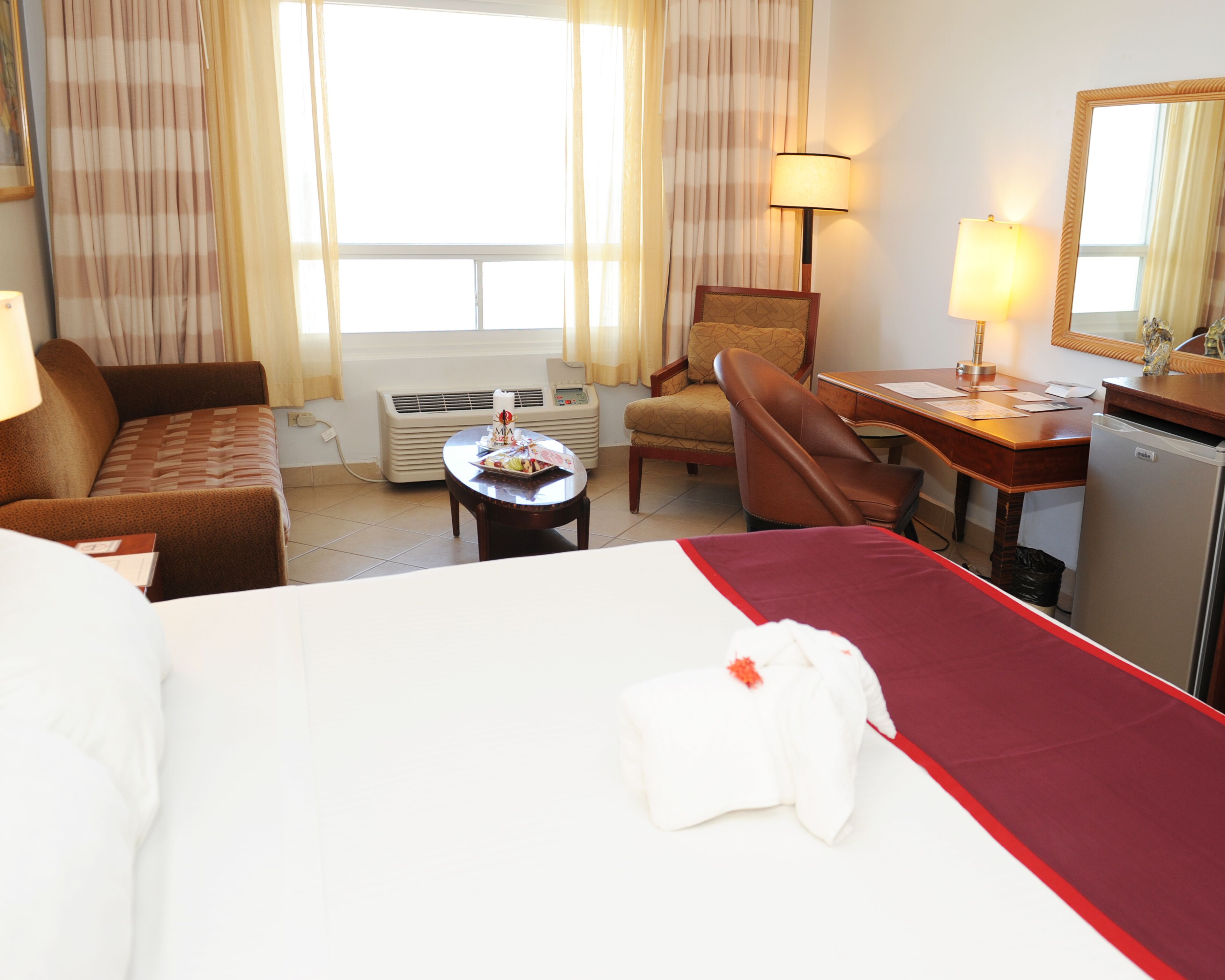 Une chambre d’hôtel comprenant un lit, un bureau, une chaise, un canapé et une table.
