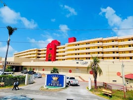 Un gran hotel con varios pisos, un edificio rojo destacado a la izquierda y un cartel de Princess Casino al frente.