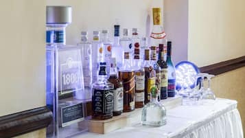 A display of various liquor bottles on a table with a white tablecloth.