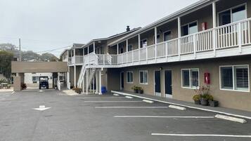 Un motel à deux étages doté d’un parking couvert et d’un escalier menant à l’étage supérieur.