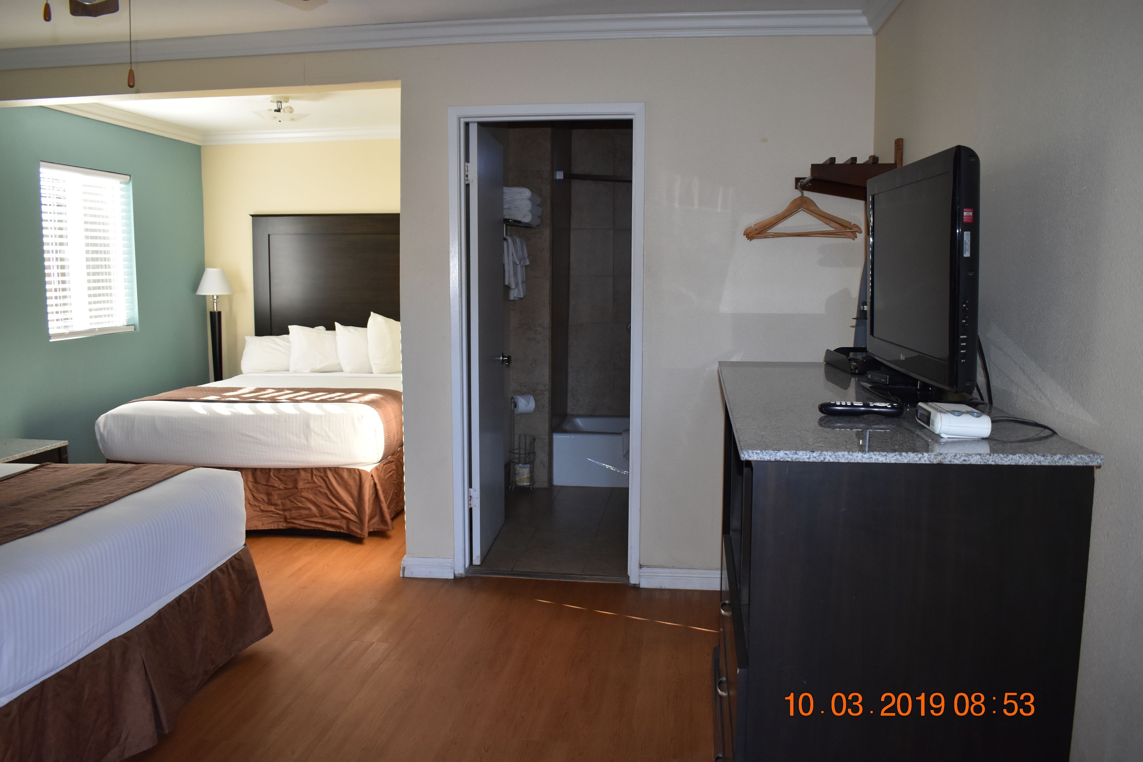 A hotel room with a bed, a desk with a television, and a walk-in closet.
