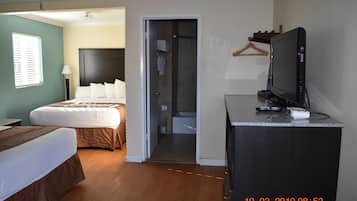 A hotel room with a bed, a desk with a television, and a walk-in closet.
