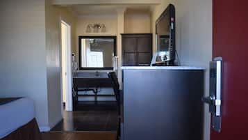 Una cocina compacta equipada con un refrigerador, un microondas y un lavamanos.