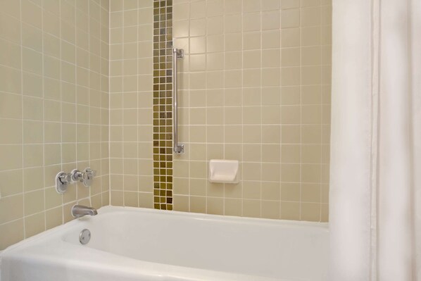 A bathroom with a bathtub, a shower area, and a toilet.