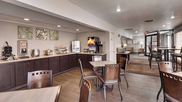A hotel lobby with a coffee station, seating area, and a view into the dining room. - SureStay by Best Western Miles City (Miles City)