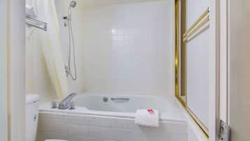 A bathroom with a bathtub, toilet, and shower.