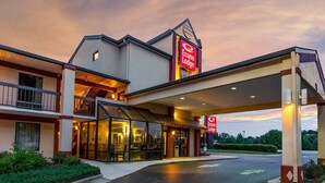 A two-story Econo Lodge with a covered entrance and a glass facade. - Econo Lodge Garner - Raleigh (Garner)