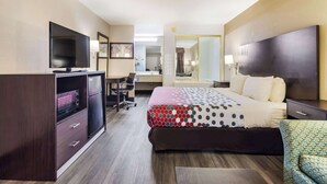 A hotel room with a bed, a desk, a television, and a wardrobe. - Econo Lodge Garner - Raleigh (Garner)