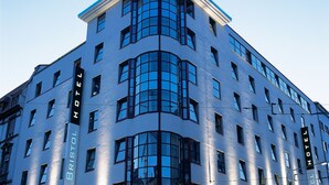 Un edificio de esquina con diseño moderno, con amplias ventanas y un llamativo letrero 