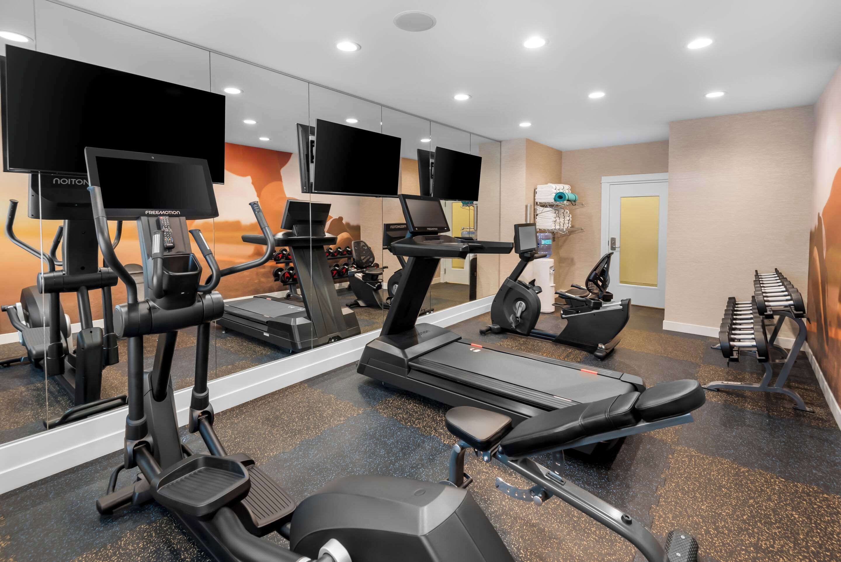 A gym with treadmills, exercise bikes, and weight machines.