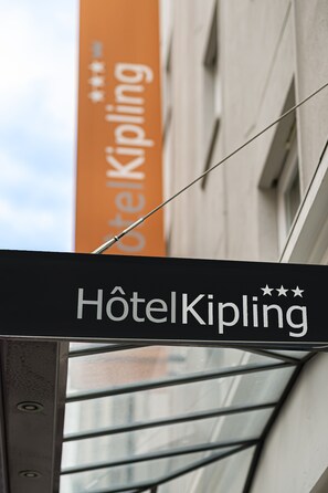 A hotel sign with the name "Hôtel Kipling" and a star rating of three stars.