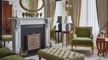A traditional room with a fireplace, green upholstered furniture, and classic decor.