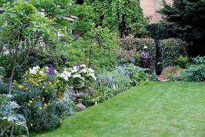 Stroll through a serene garden featuring a variety of vibrant flowers and a beautifully manicured lawn.
